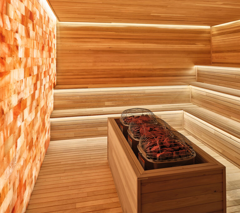 Cedar sauna interior with Himalayan salt wall, part of a luxury aquatic wellness build