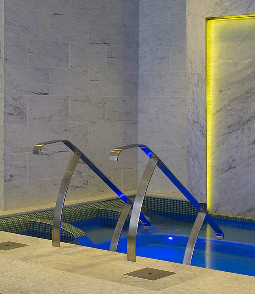 Cold plunge pool with stainless steel handrails in a marble spa, biohacking aquatic environment design by Aquatics International Group