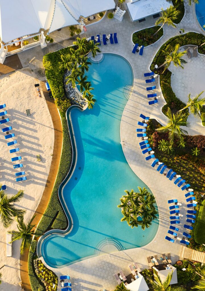 Aerial view of a luxury resort pool complex with lounge chairs and palm trees, Ritz-Carlton St. Thomas