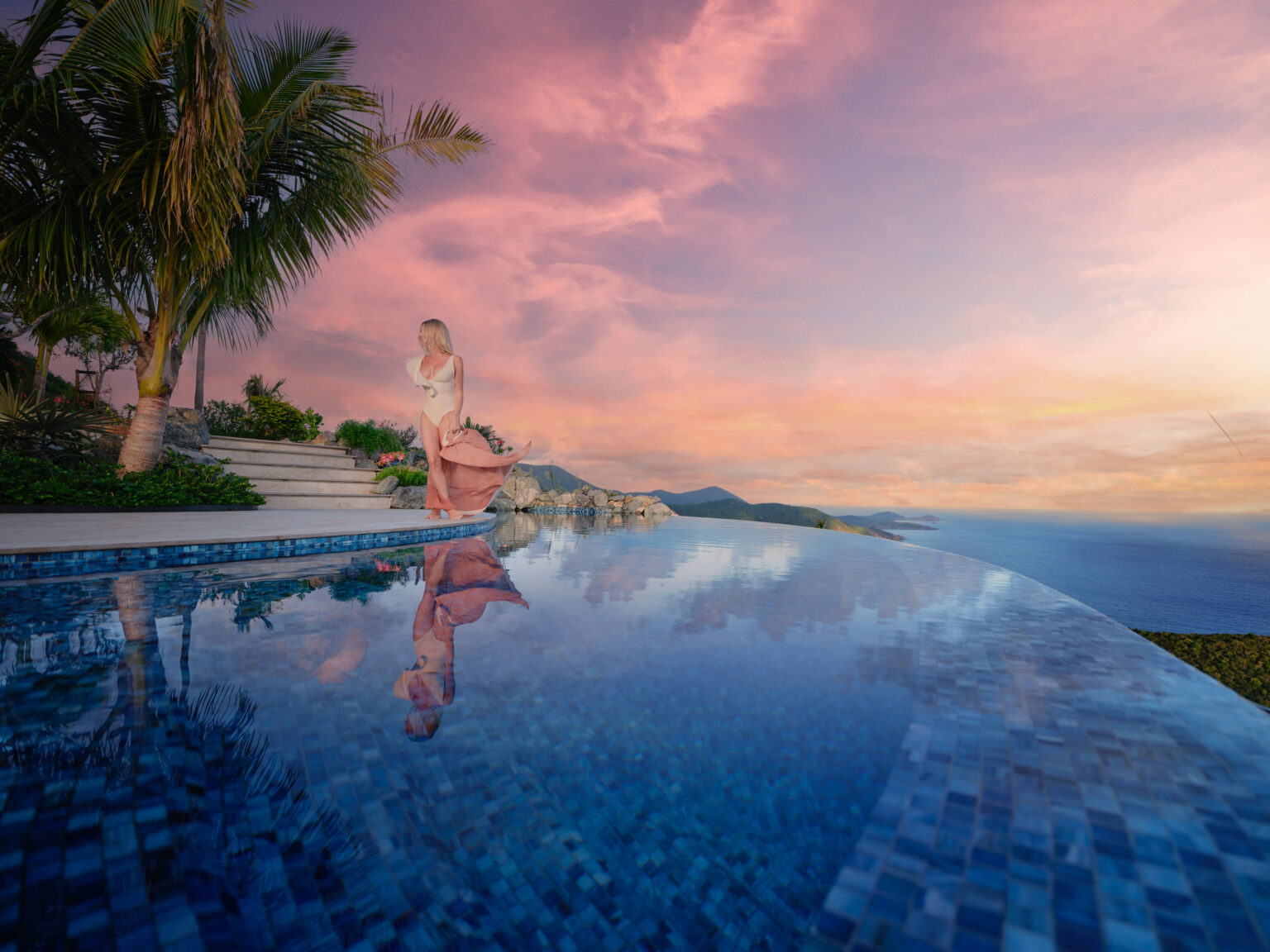 Guest wading in an infinity pool at sunset with palm trees and ocean horizon, private estate pool St. John USVI, by Aquatics International Group