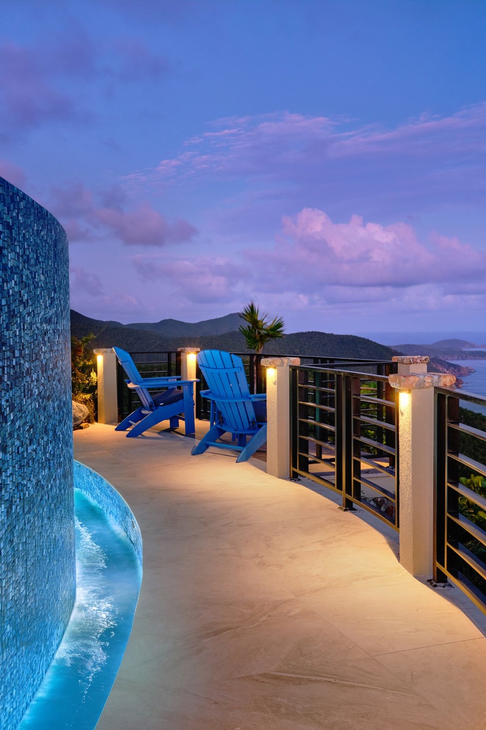 Mosaic-tiled pool wall and lit overlook terrace at dusk, St. John USVI, by Aquatics International Group